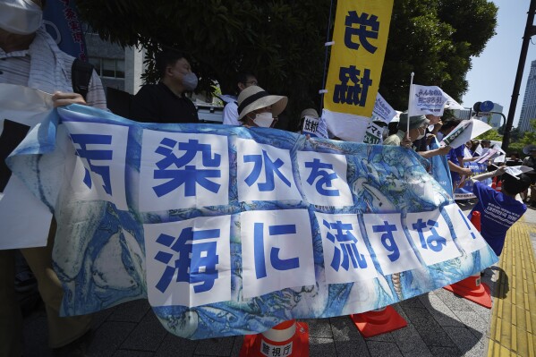 Local protesters and South Korean lawmakers hold banners against Japanese plans to release treated wastewater from the damaged Fukushima nuclear power plant, during a rally in front of the Prime Minister's office Monday, July 10, 2023, in Tokyo. The banner reads, "Do not release polluted water!" (AP Photo/Eugene Hoshiko)