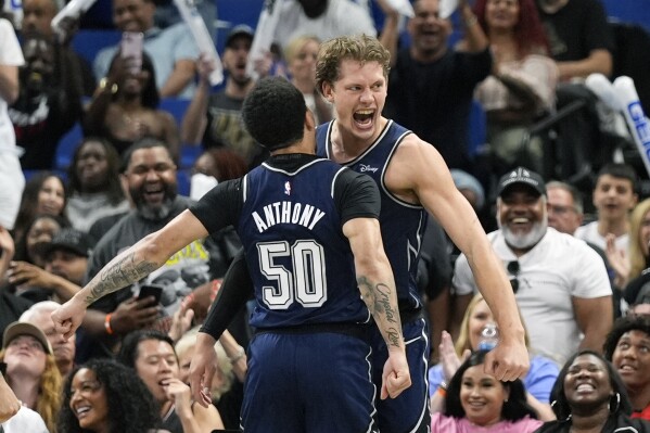 Orlando Magic center Moritz Wagner, right, celebrates as he gets a chest bump from guard Cole Anthony (50) after dunking the ball against the Chicago Bulls and drawing a foul during the second half of an NBA basketball game, Sunday, April 7, 2024, in Orlando, Fla. (AP Photo/John Raoux)