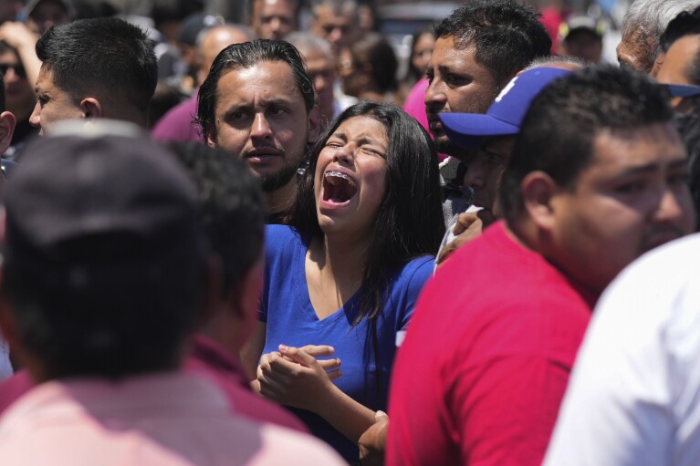A relative of an 8-year-old girl, who was kidnapped the previous day, weeps as her body is handed over to family in Taxco, Mexico, Thursday, March 28, 2024. (AP Photo/Fernando Llano)