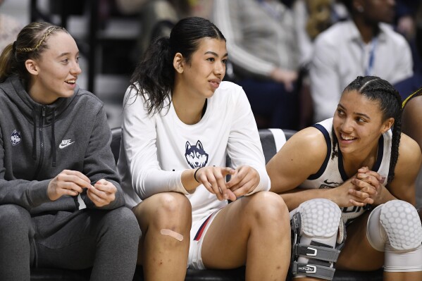 FILE - UConn's Azzi Fudd, right, smiles toward teammates Paige Bueckers, left, and Jana El Alfy, center, during the second half of an NCAA college basketball game in the quarterfinals of the Big East Conference tournament at Mohegan Sun Arena, Saturday, March 4, 2023, in Uncasville, Conn. UConn freshman forward Jana El Alfy will miss the 2023-24 season with a ruptured left Achilles tendon, the school announced on Tuesday, July 25, 2023. The 6-foot-5 forward from Egypt sustained the injury Sunday in her country’s final game in the FIBA U19 World Cup in Spain.(AP Photo/Jessica Hill, File)