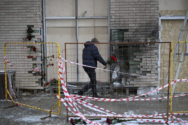 A man lays flowers on Wednesday, Dec. 18, 2024, at the apartment block in Moscow, Russia, where a bomb killed Lt. Gen. Igor Kirillov, the head of Russia's Radiation, Biological and Chemical Defense Forces, and his assistant Ilya Polikarpov. (AP Photo/Dmitry Serebryakov)