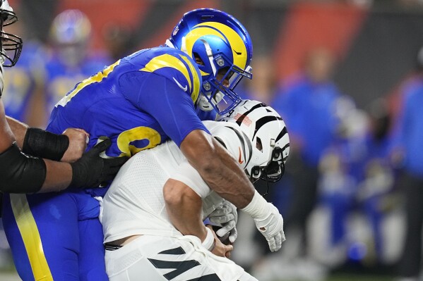Cincinnati Bengals quarterback Joe Burrow, right, is sacked for an 8-yard loss by Los Angeles Rams defensive tackle Aaron Donald during the first half of an NFL football game Monday, Sept. 25, 2023, in Cincinnati. (AP Photo/Darron Cummings)