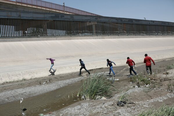FILE - In this June 15, 2019, file photo, migrants cross the Rio Bravo illegally to surrender to the American authorities, on the U.S.-Mexico border between Ciudad Juarez and El Paso. A legal team that recently interviewed more than 60 children at a Border Patrol station in Texas warns that a traumatic situation is unfolding for some 250 infants, children and teens locked up for up to 27 days without adequate food, water and sanitation, according to a report published Thursday, June 20. (AP Photo/Christian Torres, File)