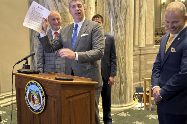 Missouri state Sen. Bill Eigel, a Republican member of the state Freedom Caucus, waives a paper containing criticisms of the Freedom Caucus that had been prepared by Republican Senate leaders for a press conference on Thursday, Jan. 25, 2024, at the state Capitol in Jefferson City, Mo. Republican leaders had left the paper on a lectern which the Freedom Caucus then used for its own press conference. (AP Photo/David A. Lieb)