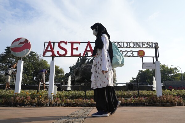 A pedestrian passes by a sign of the Association of Southeast Asian Nations (ASEAN) in Jakarta, Indonesia, Monday, July 10, 2023. Myanmar's prolonged civil strife, tensions in the disputed South China Sea and concern over arms buildups in the region are expected to dominate the agenda when Southeast Asia's top diplomats gather for talks this week in Indonesia. (AP Photo/Achmad Ibrahim)