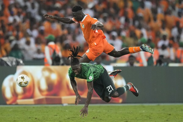 Ivory Coast 's Karim Konate, top, and Nigeria's Calvin Bassey battle for the ball during the African Cup of Nations final soccer match between Ivory Coast and Nigeria, at the Olympic Stadium of Ebimpe in Abidjan, Ivory Coast, Sunday, Feb. 11, 2024. (APPhoto/Themba Hadebe)