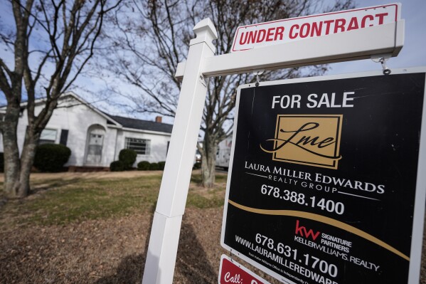 A sign indicating that a home is under contract is shown on Tuesday, Jan. 16, 2024, in Kennesaw, Ga. On Friday, the National Association of Realtors reports on existing home sales for December. (AP Photo/Mike Stewart)