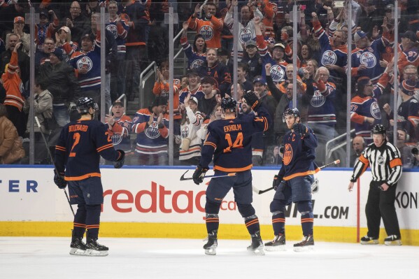 Edmonton Oilers' Evan Bouchard (2), Mattias Ekholm (14) and Connor McDavid (97) celebrate a goal against the Los Angeles Kings during the first period of an NHL hockey game Thursday, March 28, 2024, in Edmonton, Alberta. (Jason Franson/The Canadian Press via AP)