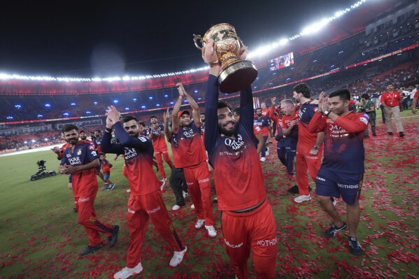 Royal Challengers Bengaluru's captain Rajat Patidar celebrates with the winners trophy after their win in the Indian Premier League final cricket match against Punjab Kings at Narendra Modi Stadium in Ahmedabad, India, Wednesday, June 4, 2025. (AP Photo/Ajit Solanki)
