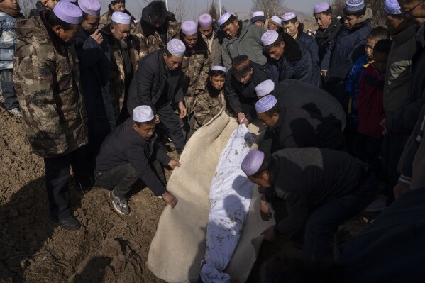 The body of Han Suofeiya who was killed in an earthquake is lowered into the ground at a cemetery in Yangwa village near Dahejia town in northwestern China's Gansu province, Wednesday, Dec. 20, 2023. (AP Photo/Ng Han Guan)