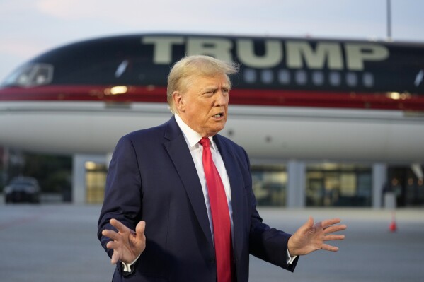 FILE - Former President Donald Trump speaks with reporters before departure from Hartsfield-Jackson Atlanta International Airport, Aug. 24, 2023, in Atlanta. A liberal group has filed a lawsuit to bar Trump from the primary ballot in Colorado. The lawsuit contends Trump is ineligible to run for the White House again under a rarely used clause in the U.S. Constitution aimed at candidates who have supported an “insurrection.” (AP Photo/Alex Brandon, File)
