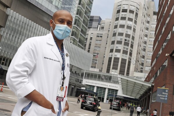 Alister Martin, an emergency room doctor at Massachusetts General Hospital, poses outside the hospital, Friday, Aug. 7, 2020, in Boston. Martin founded the organization "VotER" to provide medical p...