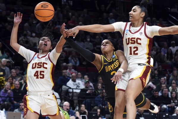 Southern California guard JuJu Watkins (12) and Southern California guard Kayla Padilla (45) block a shot by Baylor guard Sarah Andrews during the second half of a Sweet 16 college basketball game in the NCAA Tournament, Saturday, March 30, 2024, in Portland, Ore. Southern California won 74-70. (AP Photo/Steve Dykes)