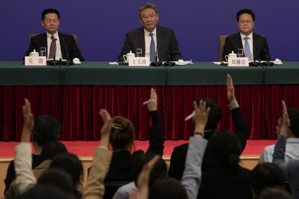 Key Chinese finance and economy officials look on as journalists raise their hands to ask questions at a press conference on the sideline of the National People's Congress in Beijing, Wednesday, March 6, 2024. Some of the most closely watched press conferences happen during China's meeting of its ceremonial legislature. The meeting is a rare opportunity to directly engage with officials, yet the space for that engagement is shrinking. (AP Photo/Ng Han Guan)