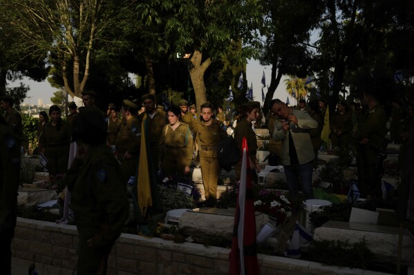 Israeli soldiers and family members visit the graves of fallen soldiers ahead of Israel's annual Memorial Day at Mount Herzl military cemetery in Jerusalem, Thursday, May 9, 2024. Israel marks its annual Memorial Day in remembrance of soldiers who died in the nation's conflicts, beginning at dusk Sunday, May 12, until Monday evening, May 13. (AP Photo/Ohad Zwigenberg)