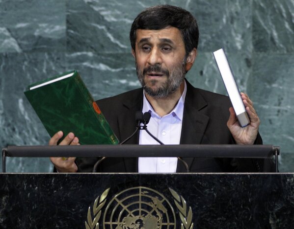 
              FILE - In this Sept. 23, 2010 file photo, Mahmoud Ahmadinejad, President of Iran, holds up a copies of the Quran, left, and Bible, right, as he addresses the 65th session of the United Nations General Assembly at U.N. headquarters. Ahmadinejad prompted disgusted walkouts from the assembly in 2010 when he questioned whether the Sept. 11 attacks were staged. He suggested an inside job, arguing that only an explosion, not planes could have brought down the twin towers. His visits to New York caused fury among locals, but delighted the hardline wing in Iran. (AP Photo/Richard Drew, File)
            