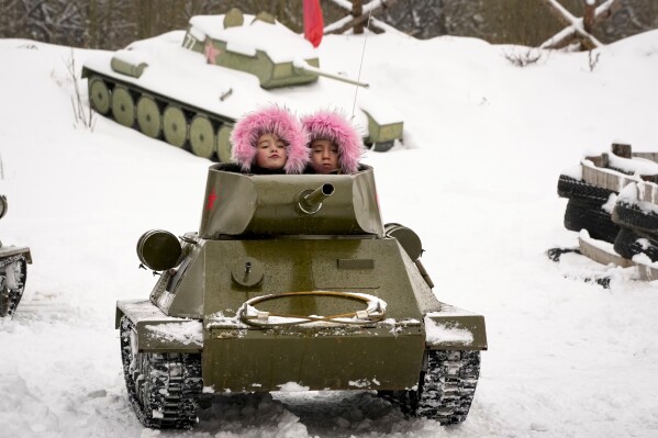 Children ride a model of World War II-era Soviet T-34 tank during a military historical festival at the family historical tank park outside St. Petersburg, Russia, Feb. 4, 2023. (AP Photo/Dmitri Lovetsky)