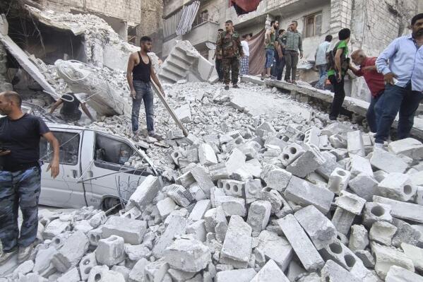 In this photo released by the Syrian official news agency SANA, Syrian Civil Defense workers and civilians work on the rubble of a destroyed building, in Aleppo, Syria, Wednesday, Sept. 7, 2022. A five-story building collapsed in Syria's northern city of Aleppo, killing several people, including three children, Syrian state television reported. (SANA via AP)