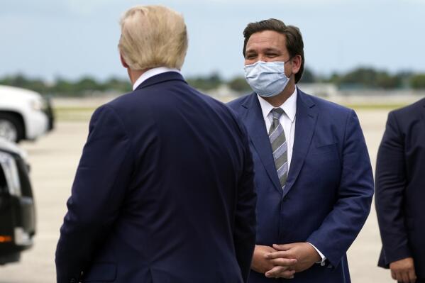 FILE - In this Sept. 8, 2020, file photo President Donald Trump greets Florida Gov. Ron DeSantis as he arrives at West Palm Beach International Airport in West Palm Beach, Fla. Now that the pandemic appears to be waning and DeSantis is heading into his reelection campaign next year, he has emerged from the political uncertainty as one of the most prominent Republican governors and an early White House front-runner in 2024 among Donald Trump's acolytes, if the former president doesn't run again. (AP Photo/Evan Vucci, File)