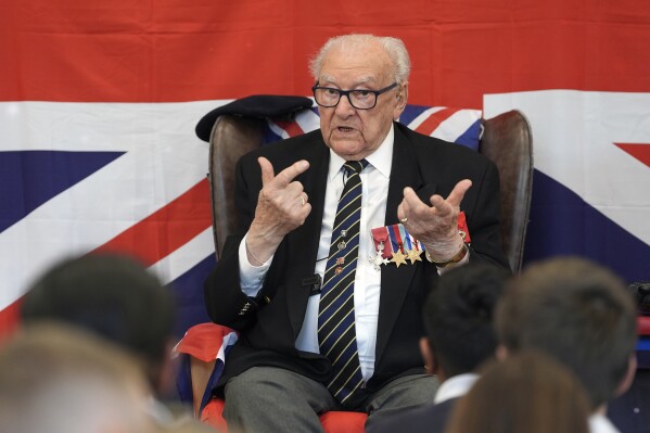 D-Day veteran and Ambassador for the British Normandy Memorial, Ken Hay, 98, who served with the 4th Dorset Regiment, speaks to children during a visit to Rush Green Primary School in Dagenham, England, Monday May 20, 2024, ahead of the 80th anniversary of the D-Day landings. (Gareth Fuller/PA via AP)