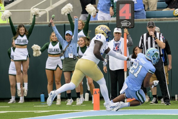 Tulane running back Makhi Hughes (21) scores a touchdown against Tulsa linebacker Julien Simon (24) during the first half an NCAA college football game in New Orleans, Saturday, Nov. 11, 2023. (AP Photo/Matthew Hinton)