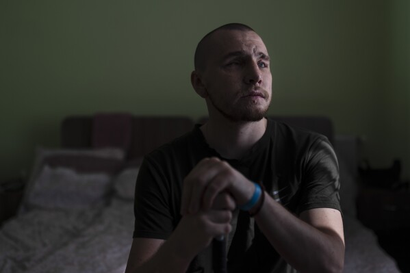 Ivan Soroka, a 27-year-old former Ukrainian soldier blinded in the war, sits for a photo in his room at a rehabilitation center designed for soldiers who lost their vision on the battlefield, near Rivne, Ukraine, Friday, July 21, 2023. Over the course of several weeks, the veterans, accompanied by their families, reside at the rehabilitation center. Most receive their first canes here, take their first walks around urban and natural environments without assistance, and learn to operate programs on phones and computers. (AP Photo/Jae C. Hong)