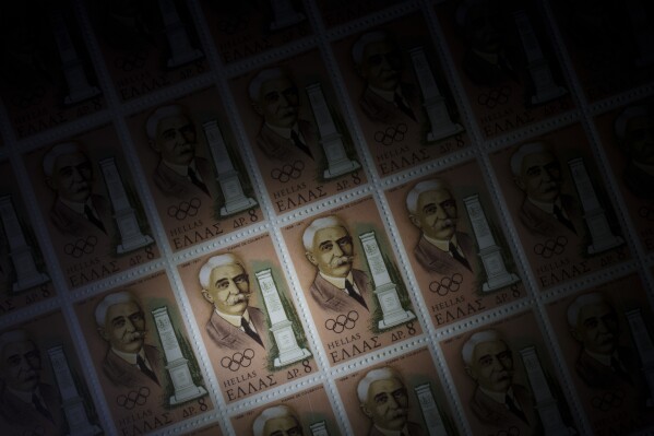 A sheet of Greek stamps showing Baron Pierre de Coubertin and his memorial in Olympia are seen in the Philatelic and Postal Museum , Ministry of Digital Governance in Athens, on Thursday, April 11, 2024. The Greek stamps showing the French Baron were issued in 1971, for the 75th anniversary of the first modern Olympic games in Athens in 1896.(AP Photo/Petros Giannakouris)