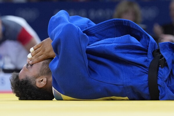 Afghanistan's Mohammad Samim Faizad reacts after their men -81kg elimination round match against Austria's Wachid Borchashvili in team judo competition at Champ-de-Mars Arena during the 2024 Summer Olympics, Tuesday, July 30, 2024, in Paris, France. (AP Photo/Eugene Hoshiko)