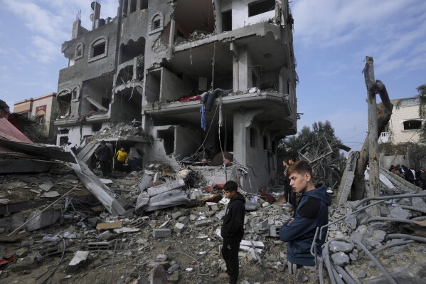 Palestinians inspect the rubble of a building of the Al Nawasrah family destroyed in an Israeli strike in Maghazi refugee camp, central Gaza Strip, Monday, Dec. 25, 2023. (AP Photo/Adel Hana)