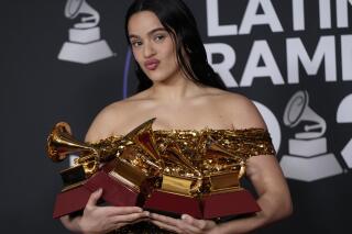 FILE - Spanish artist Rosalia poses in the press room with the awards for album of the year, best alternative music album and best recording package for "Motomami" at the 23rd annual Latin Grammy Awards at the Mandalay Bay Michelob Ultra Arena on Thursday, Nov. 17, 2022, in Las Vegas. The next Latin Grammy Awards gala will be held in southern Spain, leaving the United States for the first time, the head of its organization said Wednesday, Feb. 22, 2023. (AP Photo/John Locher, File)