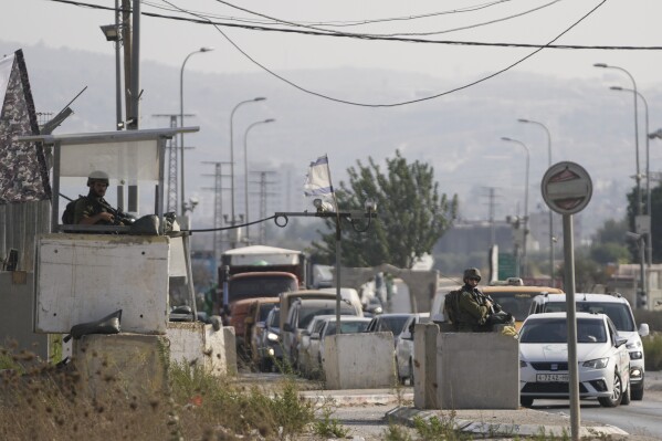 Israeli soldiers at the Hawara check point in the West Bank, Saturday, Aug. 19, 2022. Two Israelis were killed in a suspected Palestinian shooting attack on a car wash in a volatile stretch of the occupied West Bank on Saturday, the latest outburst of violence to rock the region. (AP Photo/Nasser Nasser)