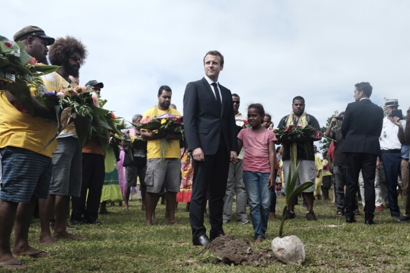 FILE - French President Emmanuel Macron pays tribute to the Kanak tribe of Hwadrilla, where the 19 Kanak militants are buried, on Ouvea Island, off New Caledonia, Saturday, May 5, 2018. The French president is heading to the South Pacific on Monday, July 24, 2023 to make France’s voice heard in a region shaping up as a prime geopolitical battleground for China and the United States. President Emmanuel Macron’s trip to Papua New Guinea, Vanuatu and New Caledonia comes as French forces take part in massive U.S.-Australian-led military exercises in the region. (AP Photo/Theo Rouby, file)