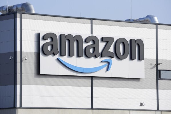 FILE - An Amazon company logo is seen on the facade of a company's building in Schoenefeld near Berlin, March 18, 2022. European regulators said Monday, Nov. 27, 2023, that Amazon’s proposed acquisition of robot vacuum maker iRobot may harm competition. (AP Photo/Michael Sohn, File)