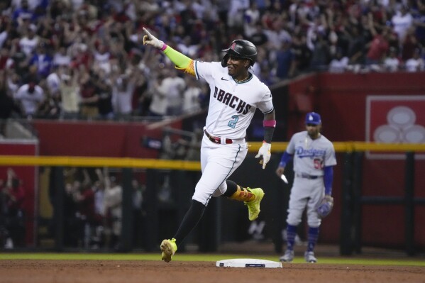 Arizona Diamondbacks' Geraldo Perdomo celebrates as he rounds the bases after hitting a home run during the third inning in Game 3 of a baseball NL Division Series against the Los Angeles Dodgers, Wednesday, Oct. 11, 2023, in Phoenix. (AP Photo/Rick Scuteri)