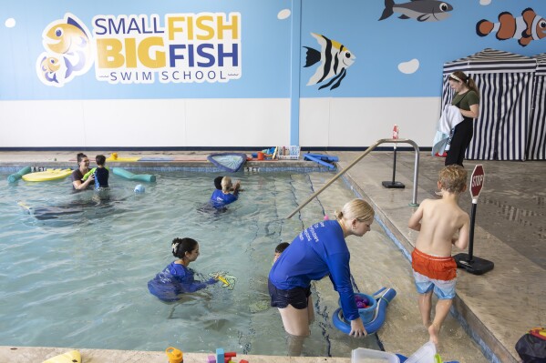 In this handout photo provided by Children's Services Council of Palm Beach County, swim instructors work with students during an autism-specific swim class at Small Fish Big Fish, Tuesday, April 1, 2025 in West Palm Beach, Fla. (Ben Rusnak /Children's Services Council of Palm Beach County via AP)
