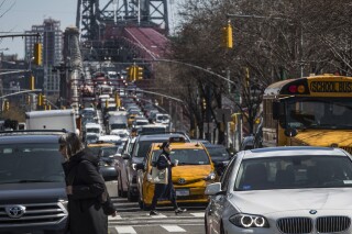 FILE - Pedestrians cross Delancey Street as congested traffic from Brooklyn enters Manhattan over the Williamsburg Bridge, March 28, 2019, in New York. New York Gov. Kathy Hochul on Wednesday, June 5, 2024 indefinitely delayed implementation of a plan to charge motorists big tolls to enter the core of Manhattan, just weeks before the nation's first “congestion pricing” system was set to launch. (AP Photo/Mary Altaffer, File)