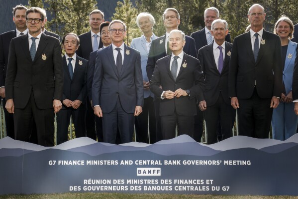 Canada's Finance Minister Francois-Philippe Champagne, centre right, and Governor of the Bank of Canada Tiff Macklem, centre left, pose for a family photo with their colleagues at the G7 Finance Ministers meeting in Banff, Alta., Wednesday, May 21, 2025. (Jeff McIntosh /The Canadian Press via AP)