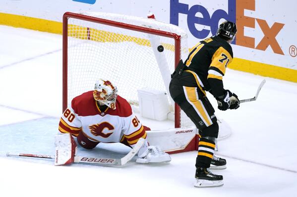 Pittsburgh Penguins' Evgeni Malkin (71) gets a backhand shot past Calgary Flames goaltender Dan Vladar for a shootout goal during an NHL hockey game in Pittsburgh, Wednesday, Nov. 23, 2022. The Penguins won 2-1. (AP Photo/Gene J. Puskar)