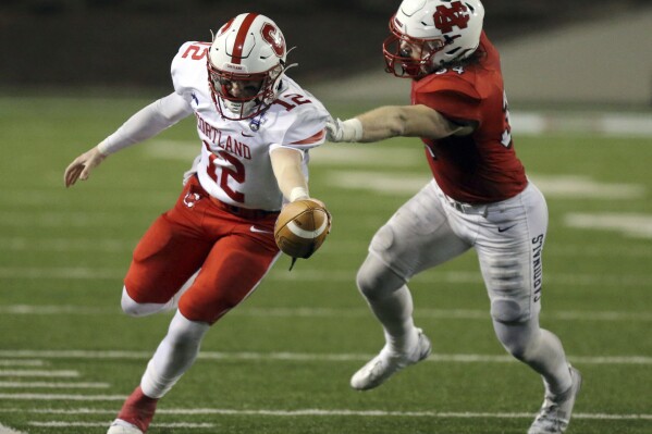 Cortland quarterback Zac Boyes (12) stretches for a first down past North Central defender BJ Adamchik (34) during the second half of the Amos Alonzo Stagg Bowl NCAA Division III championship football game in Salem, Va., Friday Dec. 15, 2023. (Matt Gentry/The Roanoke Times via AP)