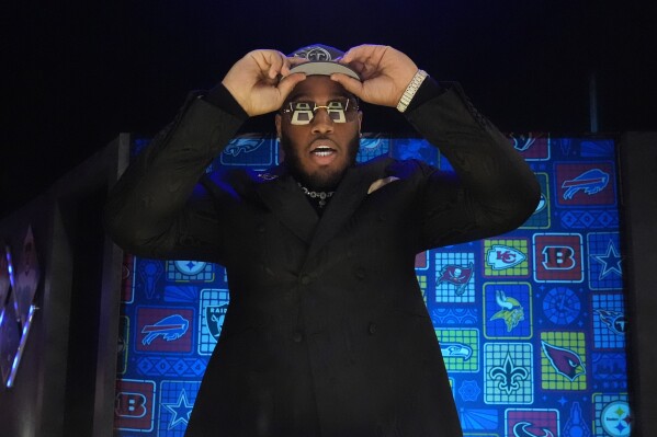 Alabama offensive lineman JC Latham puts on a hat after being chosen by the Tennessee Titans with the seventh overall pick during the first round of the NFL football draft, Thursday, April 25, 2024, in Detroit. (AP Photo/Jeff Roberson)