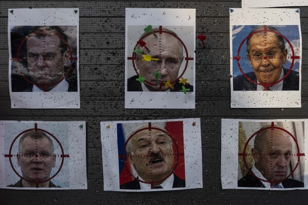 FILE - Darts are stuck on a paper target made with an image of Russian President Vladimir Putin at a popular beachside attraction in Odesa, Ukraine, Sunday, July 23, 2023. (AP Photo/Jae C. Hong, File)
