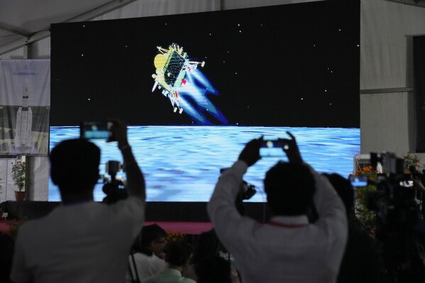 Journalists film the live telecast of spacecraft Chandrayaan-3 landing on the moon at ISRO's Telemetry, Tracking and Command Network facility in Bengaluru, India, Wednesday, Aug. 23, 2023. India has landed a spacecraft near the moon’s south pole, an uncharted territory that scientists believe could hold vital reserves of frozen water and precious elements, as the country cements its growing prowess in space and technology. (AP Photo/Aijaz Rahi)