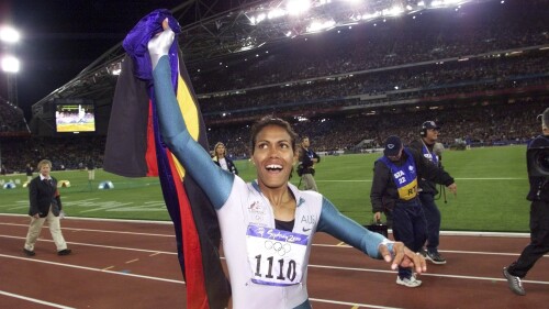 FILE - In this Sept. 25, 2000, file photo, Australia's Cathy Freeman celebrates winning the women's 400 meter race at the Summer Olympics at Olympic Stadium in Sydney. Tony Gustavsson, head coach of Australia's national women's soccer team, called a meeting. Instead of leading the team through a tactical discussion, he told the players he had different plans for the evening.