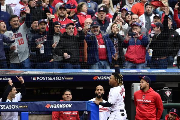 Cleveland Guardians' Jose Ramirez, center, waves to the fans from the dugout following his two-run home run in the sixth inning of a wild card baseball playoff game against the Tampa Bay Rays, Friday, Oct. 7, 2022, in Cleveland. (AP Photo/David Dermer)