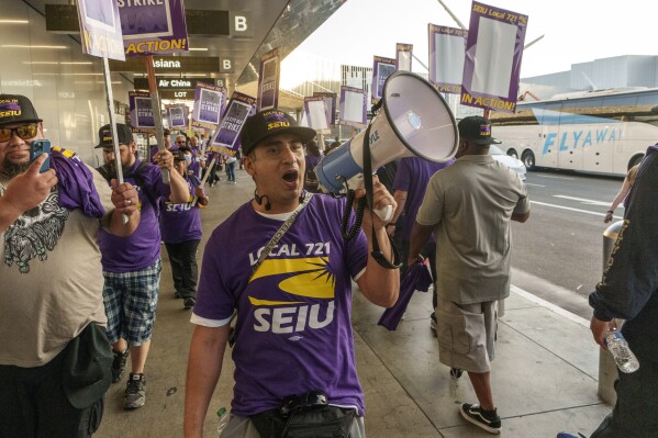 Los Angeles city employees with SEIU Local 721 join a picket line at the Los Angeles International Airport in Los Angeles on Tuesday, Aug. 8, 2023. Thousands of Los Angeles city employees, including sanitation workers, engineers and traffic officers, walked off the job for a 24-hour strike alleging unfair labor practices. The union said its members voted to authorize the walkout because the city has failed to bargain in good faith and also engaged in labor practices that restricted employee and union rights. (AP Photo/Damian Dovarganes)