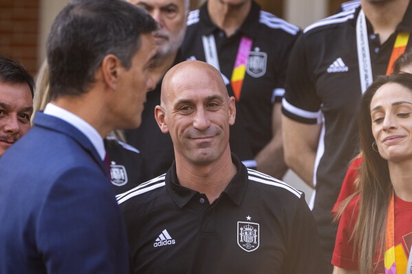 FILE - President of Spain's soccer federation Luis Rubiales, stands with Spain's Women's World Cup soccer team after being received by Spain's Prime Minister Pedro Sanchez, left, at La Moncloa Palace in Madrid, Spain, Tuesday, Aug. 22, 2023. The kiss by Luis Rubiales has unleashed a storm of fury over gender equality that almost marred the unprecedented victory but now looks set to go down as a milestone in both Spanish soccer history but also in women's rights.(AP Photo/Manu Fernandez, file)