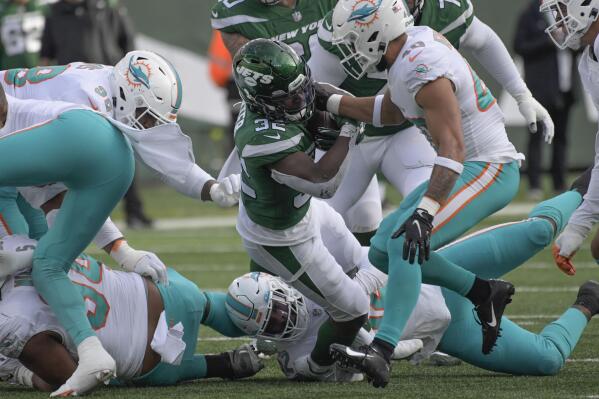 New York Jets running back Michael Carter, center, carries the ball during the first half of an NFL football game against the Miami Dolphins, Sunday, Nov. 21, 2021, in East Rutherford, N.J. (AP Photo/Bill Kostroun)