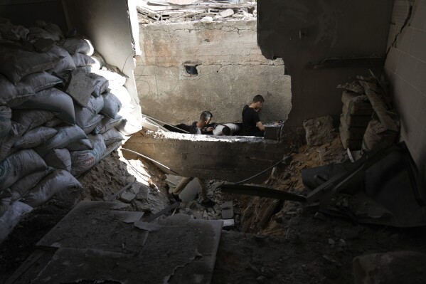 Palestinians inspect the entrance to a tunnel under a damaged mosque in the Jenin refugee camp in the West Bank, Wednesday, July 5, 2023, after the Israeli army withdrew its forces from the militant stronghold. (AP Photo/Majdi Mohammed)