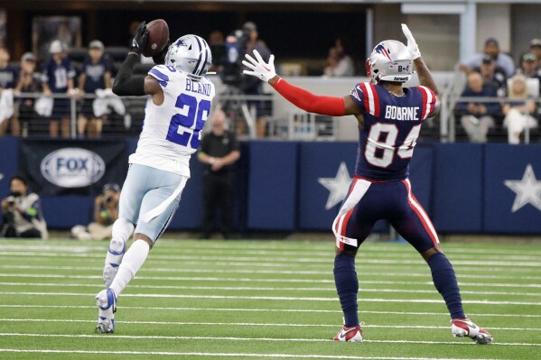 Dallas Cowboys cornerback DaRon Bland (26) intercepts a pass intended for New England Patriots wide receiver Kendrick Bourne (84) in the first half of an NFL football game in Arlington, Texas, Sunday, Oct. 1, 2023. Bland returned the interception for a touchdown. (AP Photo/Michael Ainsworth)