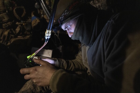 A Ukrainian soldier launches a drone attack against Russians APC on the frontline near Klishchiivka the Donetsk region, Ukraine, Friday, Feb. 19, 2024. (Iryna Rybakova via AP)